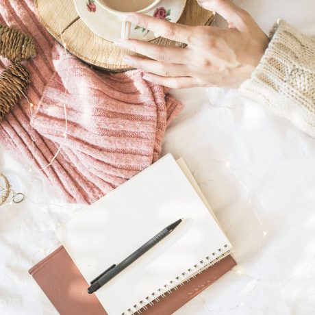 notebook-pen-near-hands-with-beverage